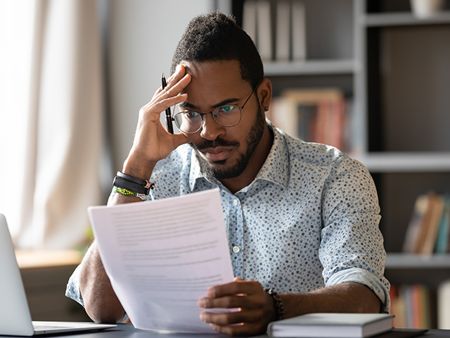 young man looking a document visably upset